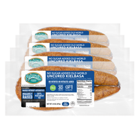 Four packages of Pederson's No Sugar Added Old World Uncured Kielbasa sausages arranged in a cascade with transparant background.