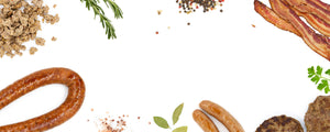 A white background image with various Pederson's products laid on top of it. It includes things like bacon, ground sausage, a hamburger patty, rope sausage, loose salt and pepper, and green herbs.